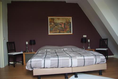 a bedroom with a bed and two tables with chairs at B&B Noflik Haule in Haule