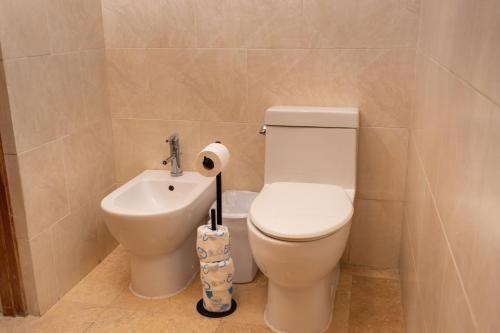 a bathroom with a toilet and a sink at Ciqala Suites Hotel - San Juan in San Juan