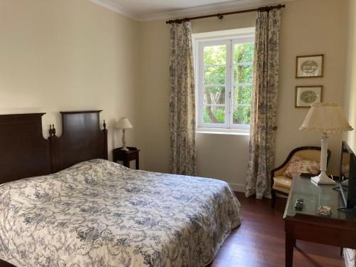 a bedroom with a bed and a window at Quinta das Palmeiras in Angra do Heroísmo