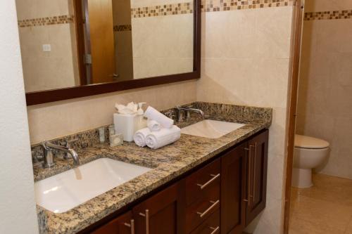 a bathroom counter with two sinks and a mirror at Ciqala Suites Hotel - San Juan in San Juan