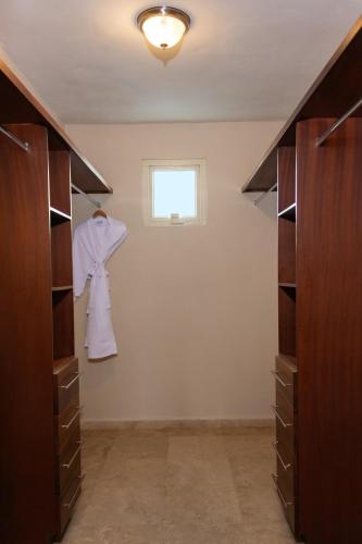 a walk in closet with wooden cabinets and a window at Ciqala Suites Hotel - San Juan in San Juan