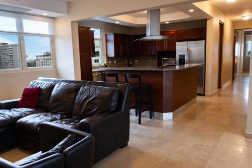 a living room with a couch and a kitchen at Ciqala Suites Hotel - San Juan in San Juan