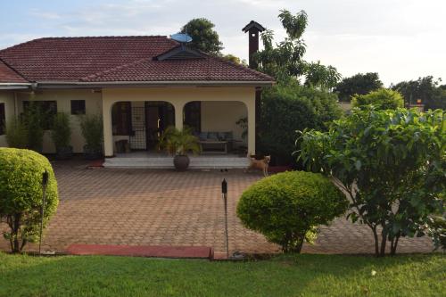 a house with a dog sitting in the front yard at Stasumo House Arusha in Arusha