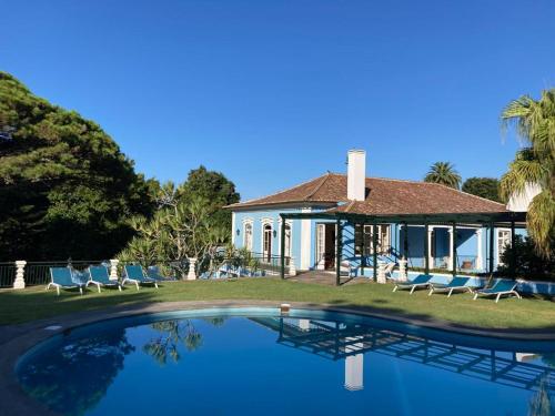 a house with a swimming pool in front of a house at Quinta das Palmeiras in Angra do Heroísmo