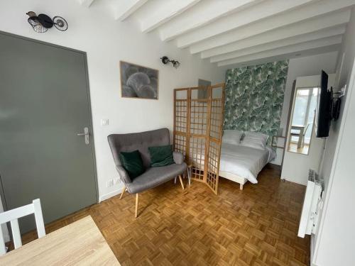 ein Wohnzimmer mit einem Bett und einem Stuhl in der Unterkunft Studio & Coworking Thème Zen B in Morsang-sur-Orge