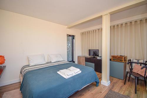 een slaapkamer met een blauw bed en handdoeken bij Lisbon Panorama IV in Lissabon