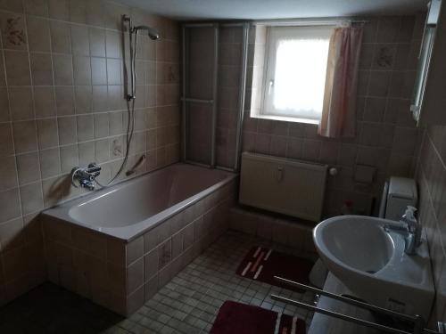 a bathroom with a tub and a sink at Harzklub Wanderheim in Wildemann