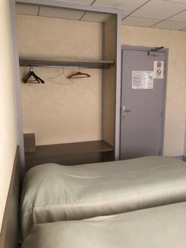 a small room with a bed and a door at Hôtel De La Mare -restaurant pour les clients sur réservation in Avrigny