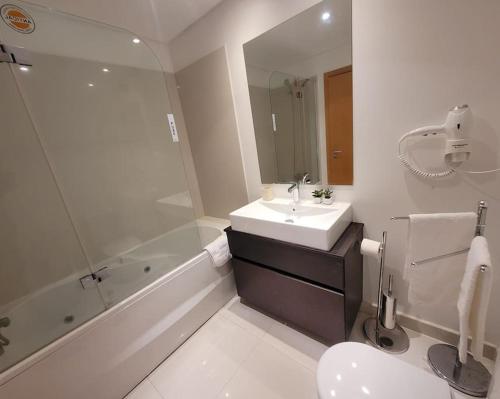 uma casa de banho com um lavatório, um WC e uma banheira em Nova Madeira Apartment Machico em Machico