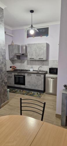 a kitchen with a wooden table and a kitchen with appliances at Santa Maura in Vico Equense