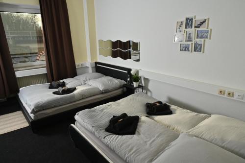 two beds in a room with black towels on them at Pott Hostel - Zimmervermietung in Essen