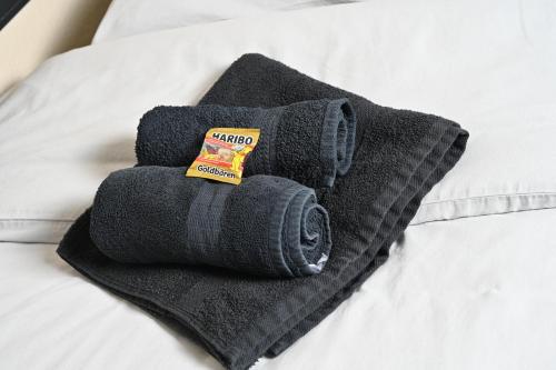 a pile of black towels on a bed at Pott Hostel - Zimmervermietung in Essen