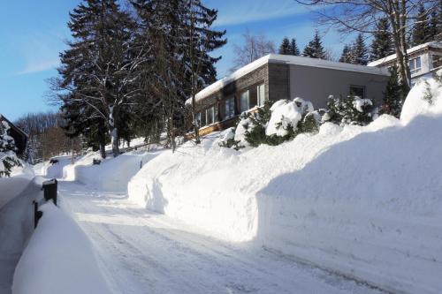 a street covered in snow next to a house at Ferienhaus Oberwiesenthal in Kurort Oberwiesenthal