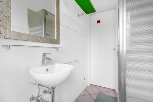 ein weißes Badezimmer mit einem Waschbecken und einem Spiegel in der Unterkunft Casa da Suite Cavour in Corsico