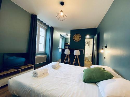 - une chambre avec un grand lit et une horloge murale dans l'établissement Casa Balzac - Studio, à Angers