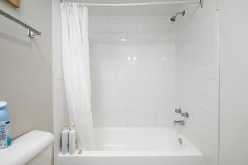 een witte badkamer met een bad en een douche bij Comfortable stay in the heart of downtown Montreal in Montreal