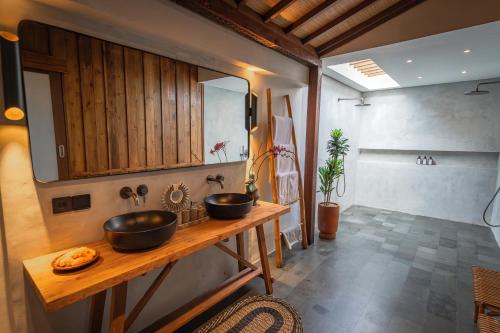 - une salle de bains avec deux lavabos sur un comptoir en bois dans l'établissement Villa Zarrin Seminyak Bali Luxury 3 bedroom villa, à Seminyak
