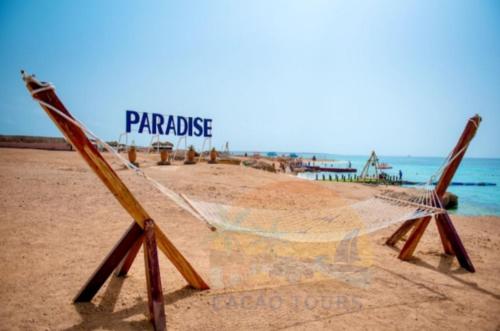 a hammock on a beach with the words paradise at Paradise island in Hurghada