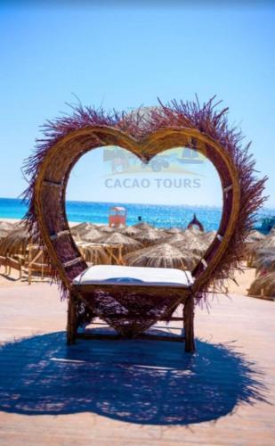 a heart shaped chair on a beach with the ocean at Paradise island in Hurghada