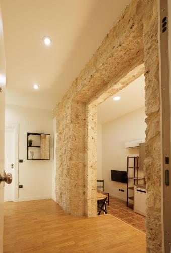 una sala de estar de planta abierta con una pared de piedra. en Apartamento Villanubla, en Villanubla