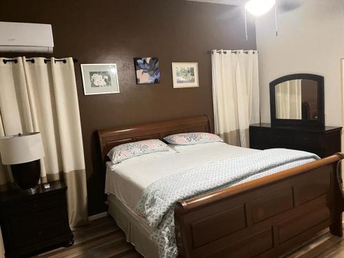sypialnia z łóżkiem, lustrem i zasłonami w obiekcie villa Jaden #1 w Road Town