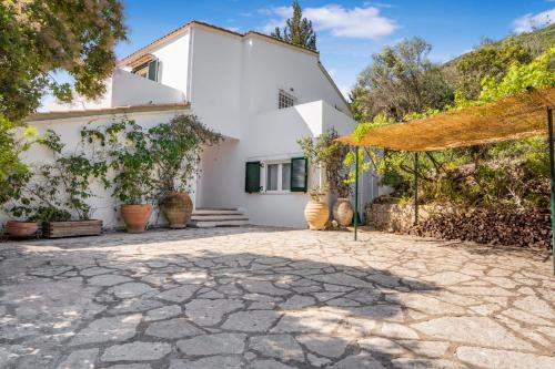 a white house with a patio and trees at Villa Viviere -Nestled just 100 meters above the charming village of Sivota in Sivota