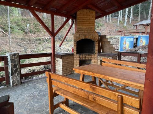 a patio with a wooden table and a brick oven at CAMERE de INCHIRIAT LA TUGUIATA in Buşteni
