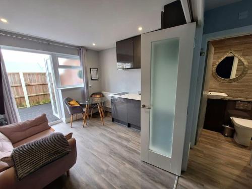 a living room with a couch and a kitchen at Boutique Annexe Close To Central Norwich & Airport in Norwich
