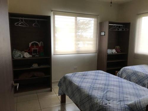 1 dormitorio con 2 camas y ventana en Casa acogedora en Alto Boquete, Las Trancas 2, en Boquete