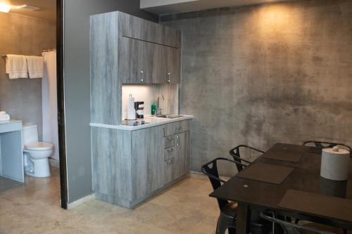 a bathroom with a sink and a table and a toilet at Ciqala Suites Hotel - San Juan in San Juan