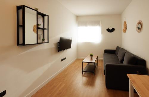 uma sala de estar com um sofá e um espelho em Villanubla Apartaments em Villanubla