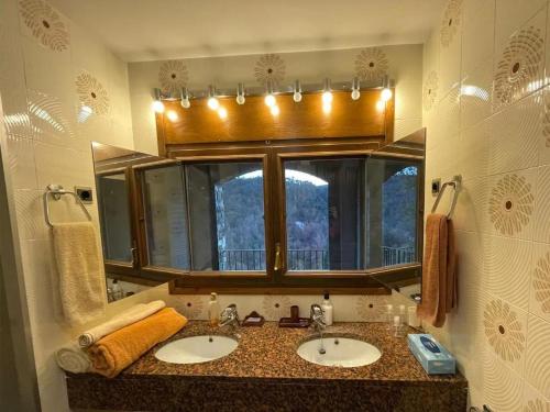 uma casa de banho com 2 lavatórios e um espelho grande em Casa Gran em San Quírico Safaja