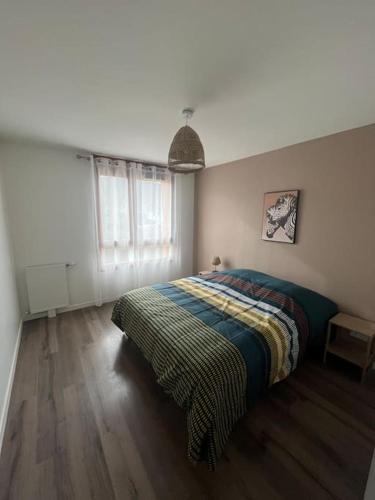 um quarto com uma cama com um cobertor listrado em Maison avec terrasse et garage proche tram em Gières
