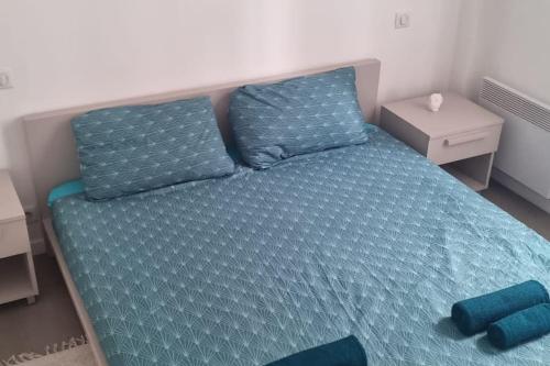- un lit avec des draps et des oreillers bleus dans l'établissement Cosy and lovely flat au Port de Nice !, à Nice