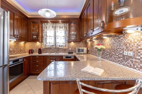 a kitchen with wooden cabinets and a granite counter top at Gavriella House in Mélanes