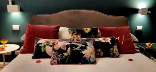 a bed with four pillows on top of it at L'Americano Luxury Rooms in Chiavari