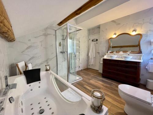 a bathroom with a tub and a toilet and a sink at Chalet Le Tilleul in Valdeblore