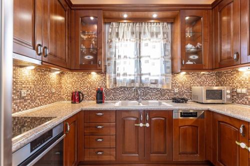 a kitchen with wooden cabinets and a sink and a window at Gavriella House in Mélanes