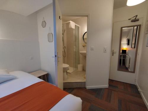 a bedroom with a bed and a bathroom with a toilet at The Originals Access, Hotel Le Canter Saumur in Saumur