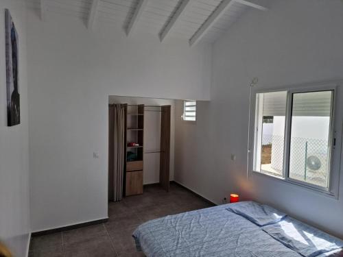 聖弗朗西斯的住宿－Au Petit Paradis，白色的卧室设有床和窗户