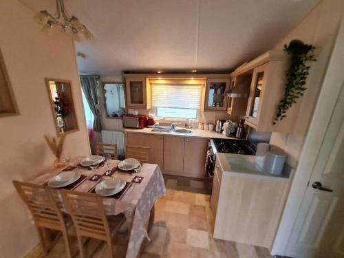a kitchen with a table and a table and chairs at Sea Shore Chalet - Rockley Park in Lytchett Minster
