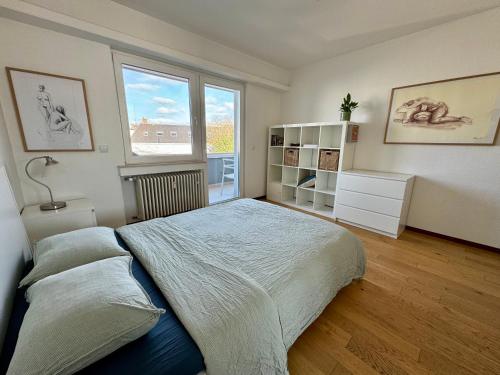 Un dormitorio con una cama grande y una ventana. en Luxembourg city appartement 105m2 with balcony, en Luxemburgo