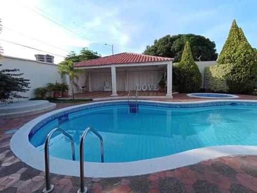 a swimming pool in front of a house at Valle Suites Boutique in Valledupar