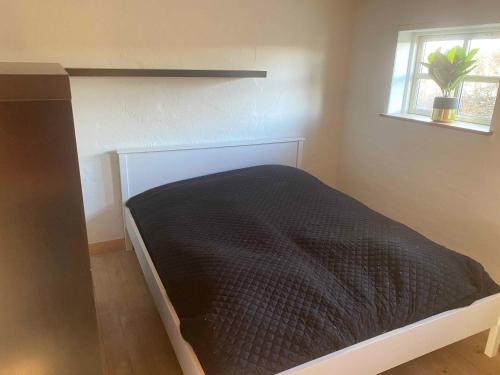 1 dormitorio con 1 cama en una habitación con ventana en Cozy Summer House In Svenborg, en Svendborg
