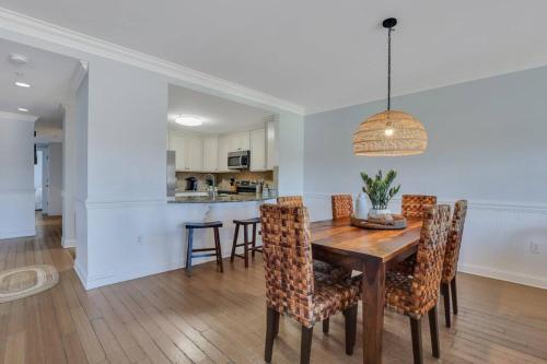 a dining room and kitchen with a wooden table and chairs at 3 BR Condo 2 Pools and Hot Tub Walk to Beach in Tybee Island