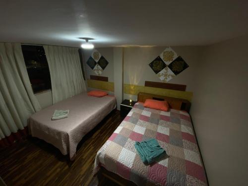 Habitación con 2 camas y ventana en Panay Guest House, en Cusco