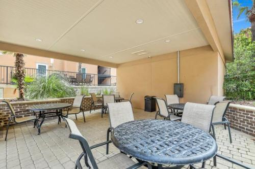 a patio with tables and chairs and a tv at 3 BR Condo 2 Pools and Hot Tub Walk to Beach in Tybee Island