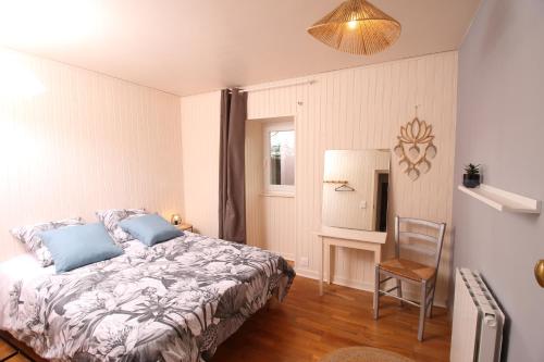 1 dormitorio con 1 cama y 1 silla en Le Chat d'à Côté, en Bord-Saint-Georges