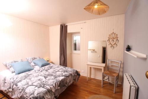 a bedroom with a bed and a chair in it at Le Chat d'à Côté in Bord-Saint-Georges