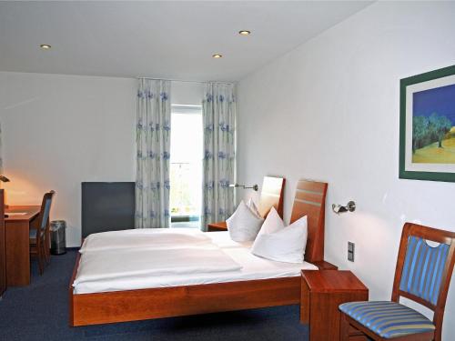 a hotel room with a bed and a window at Hotel-Restaurant Thomsen in Delmenhorst